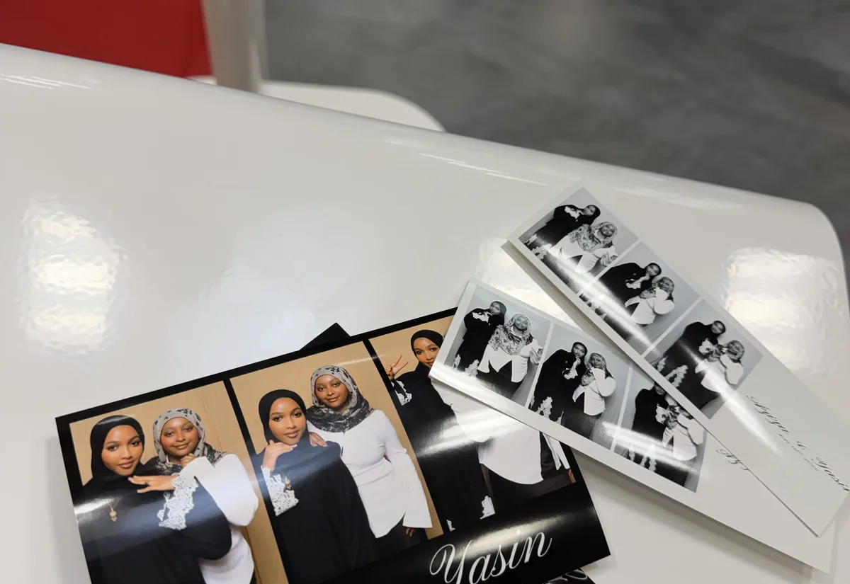 Photo booth prints laid out on top of the booth.